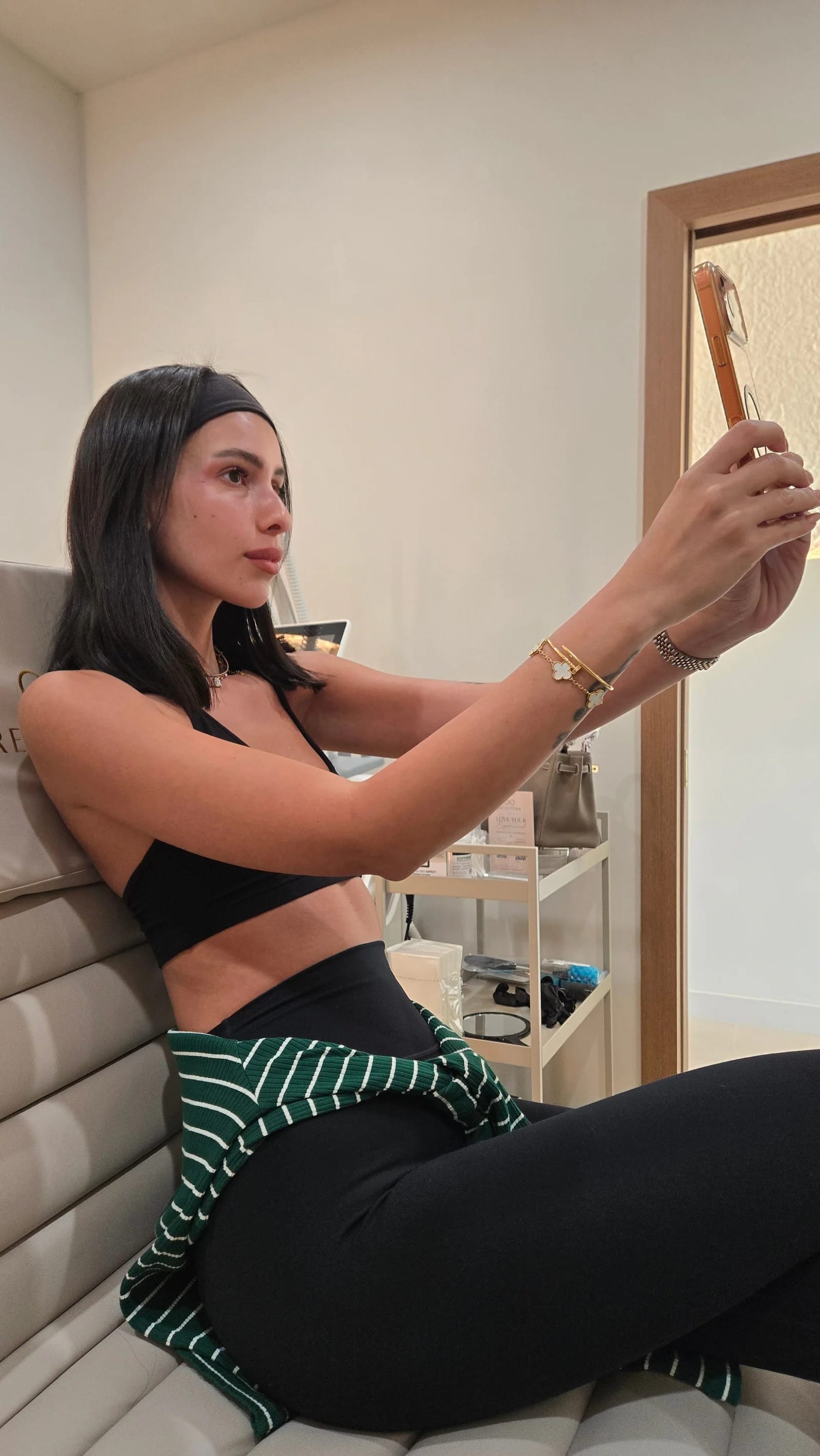 A client with glowing skin taking a selfie on the Rejuven8 treatment chair